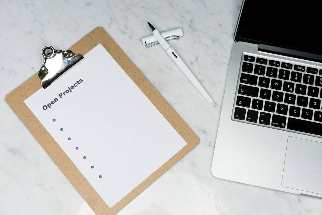 A clipboard with a checklist next to a laptop