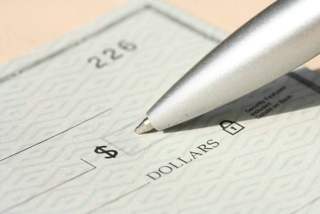 A pen resting over a blank check