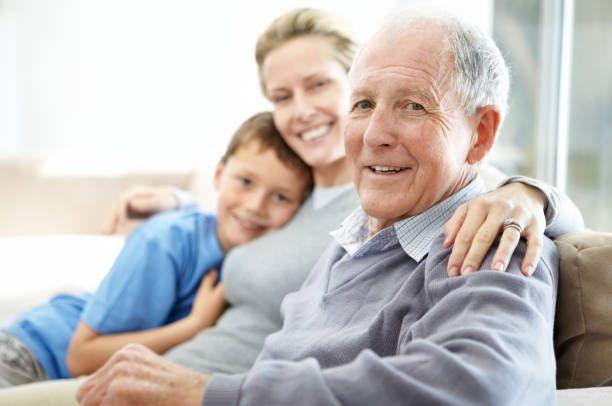 A grandfather smiling with his daughter and grandson