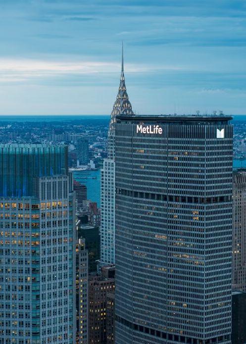 An insurance company’s headquarters tower in a city skyline at dusk